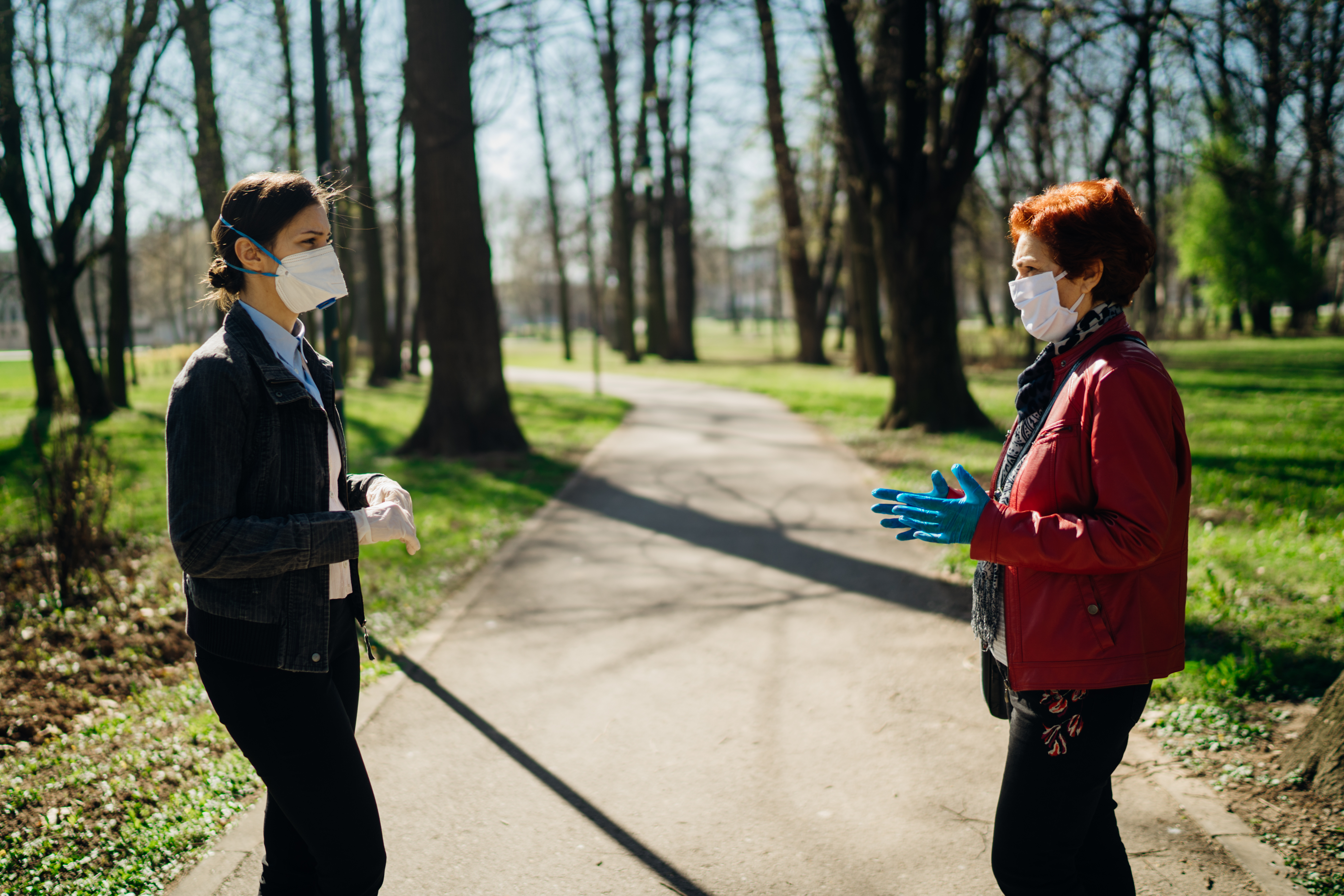 two women in masks engaged in small talk