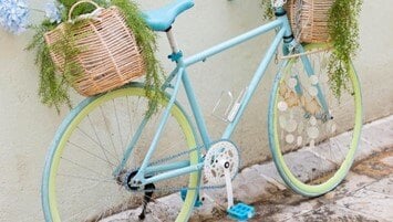 A baby blue bicycle leaning against a wall