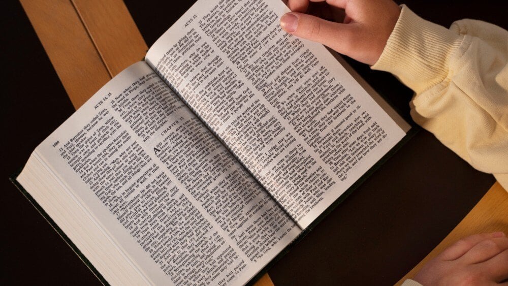 Hands holding an open Bible