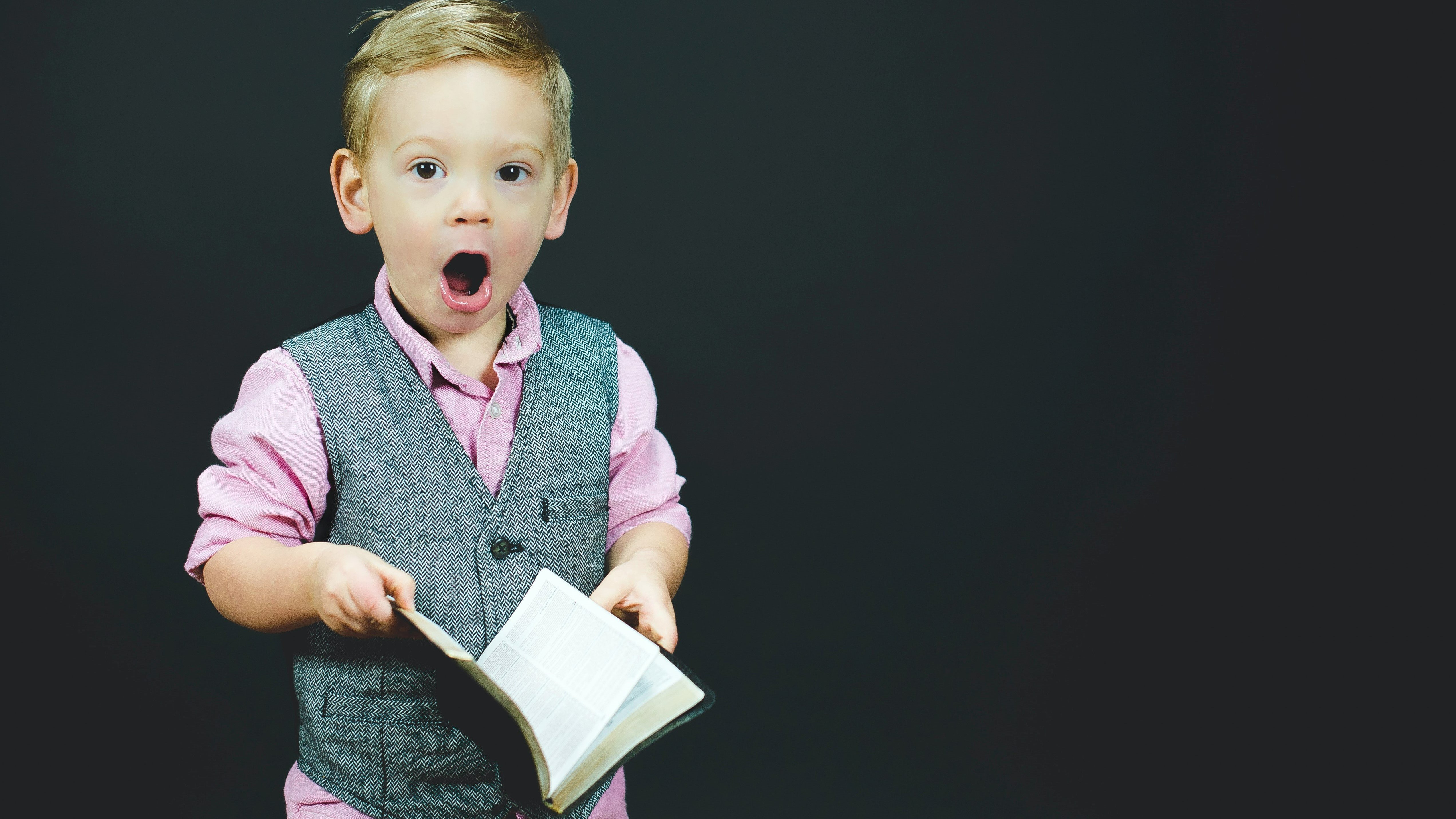 Boy with surprised expression holding book