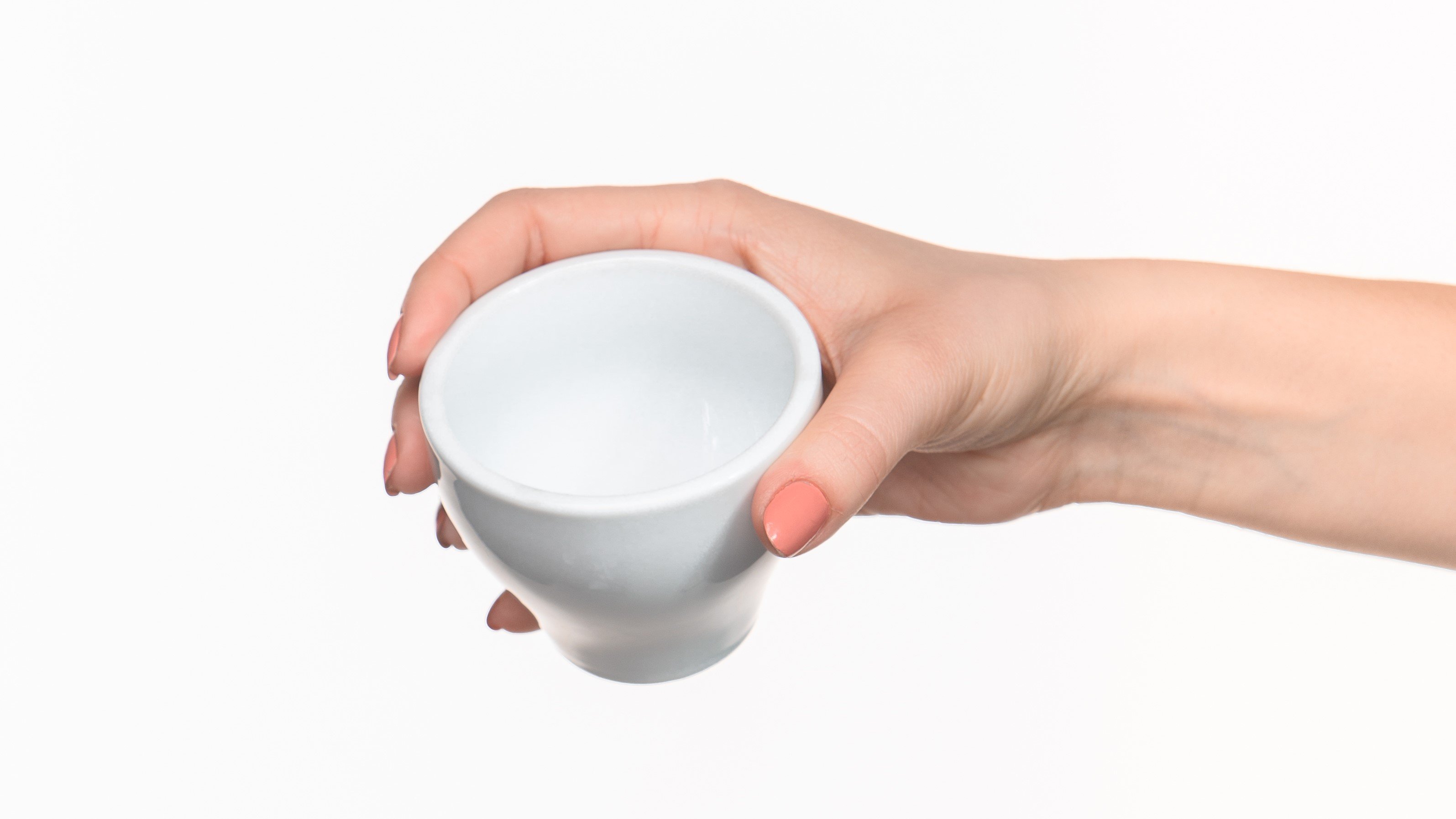 a hand holding an empty cup