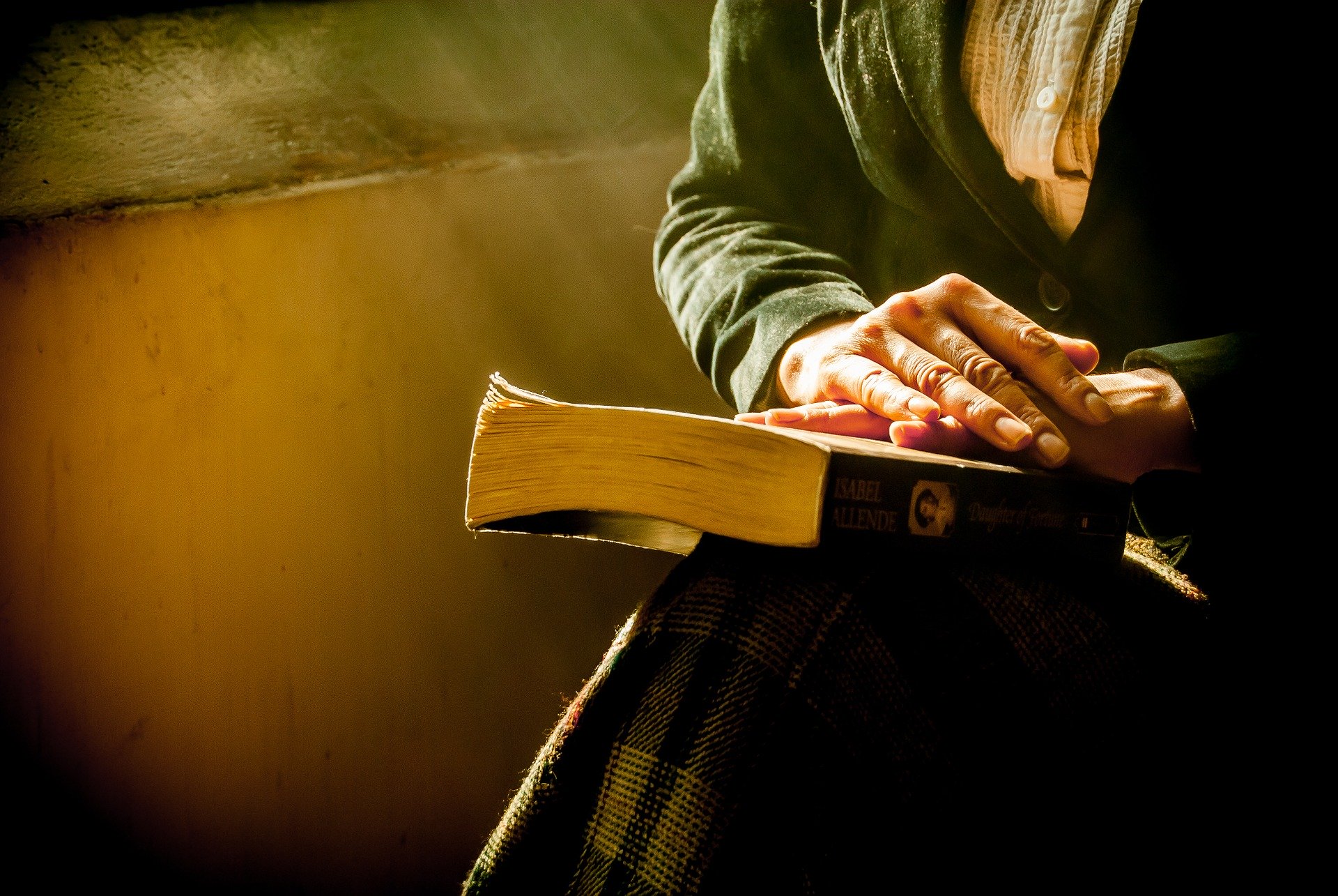 woman's hands crossed on a Bible