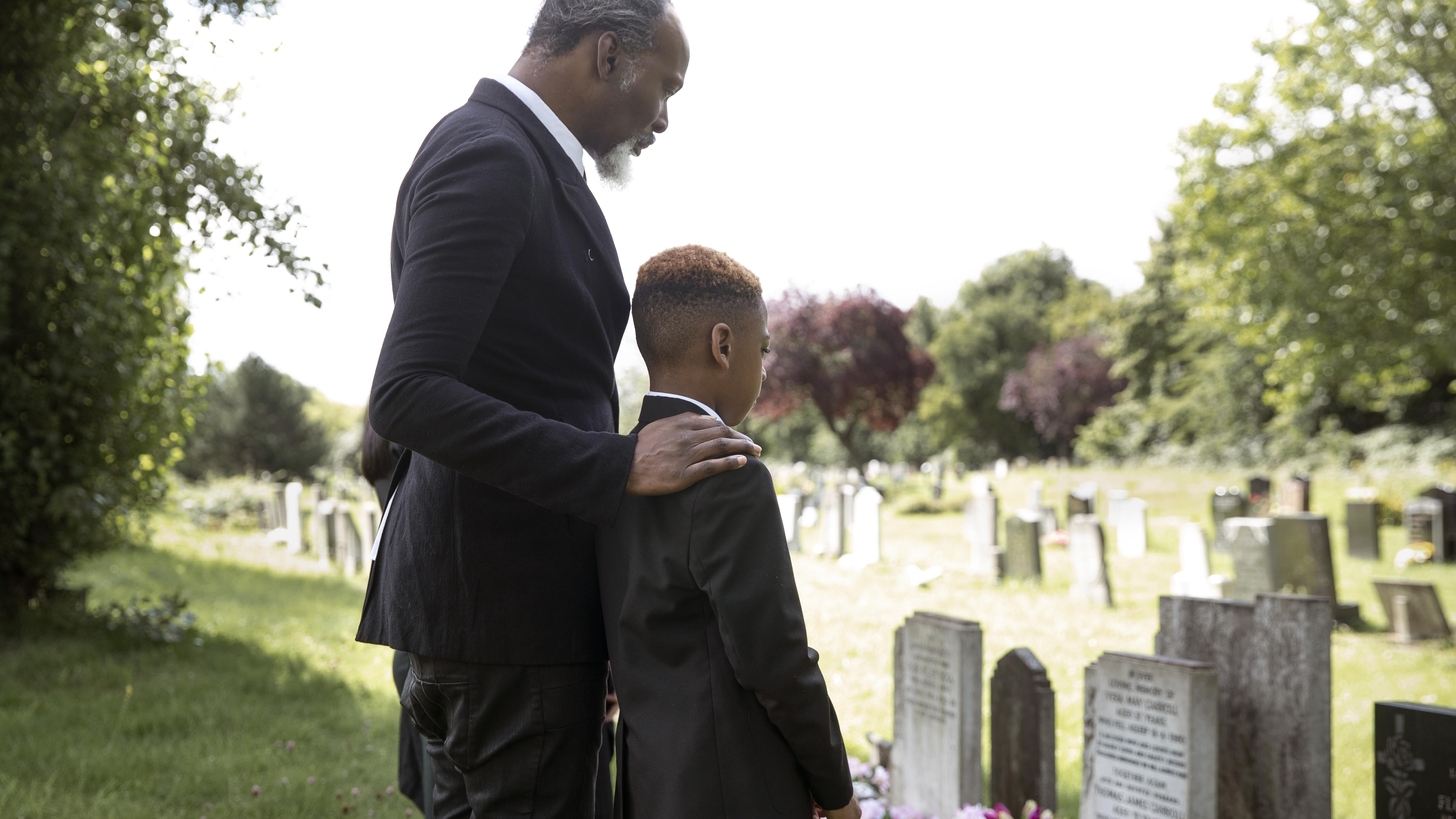 Father and young son standing in a cemetary